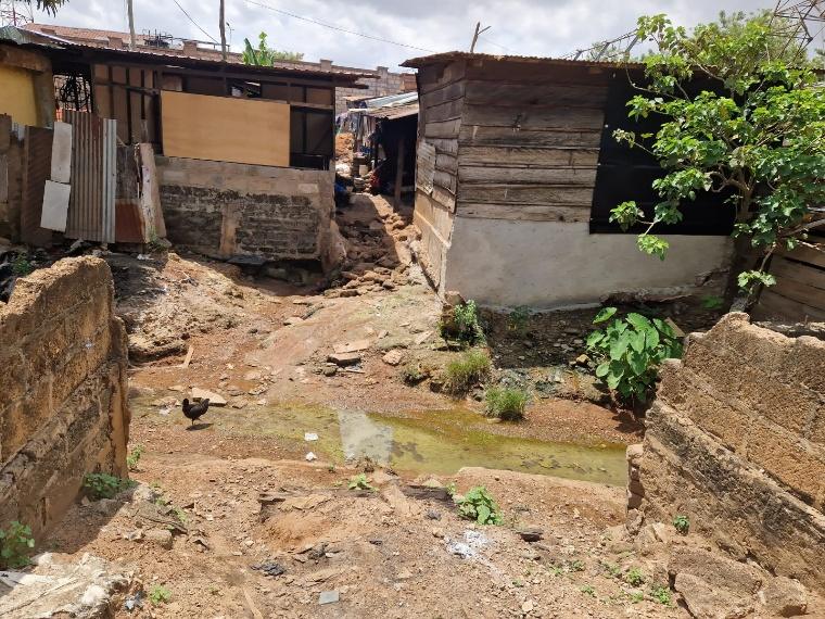 An open drain between homes in an urban community