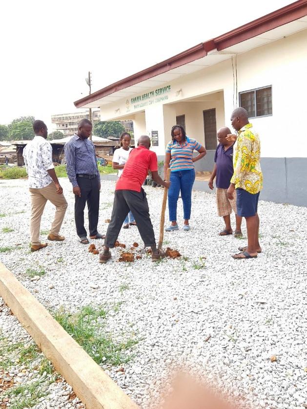A group planting seedlings outside a health facility
